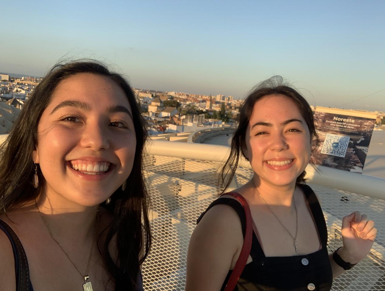 Two students in front of a sunset