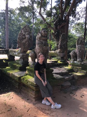 woman outside sitting by statues