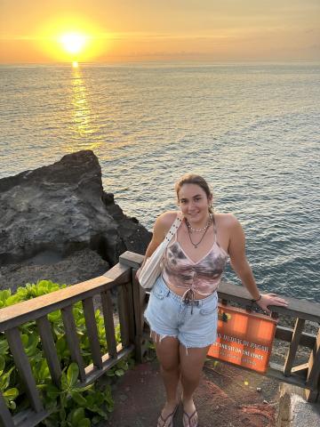 woman smiling in front of ocean sunset 