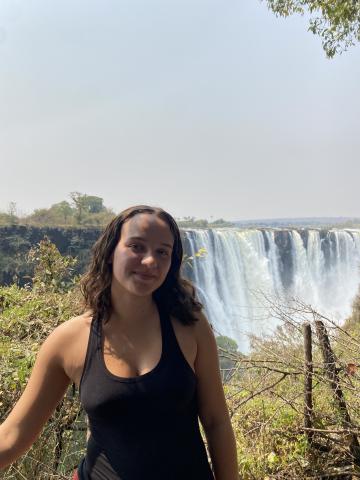 woman smiling in front of waterfall