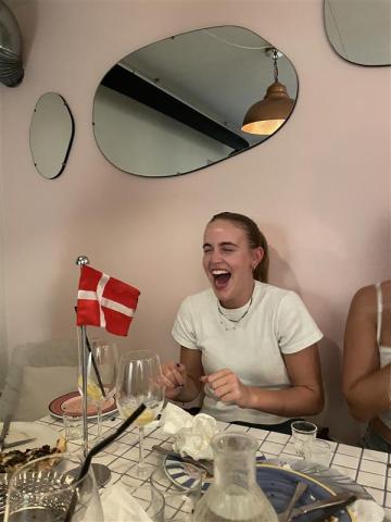 Smiling woman in front of Danish flag