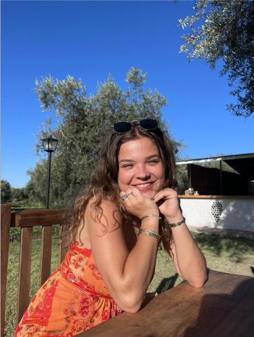 woman smiling outside in orange dress